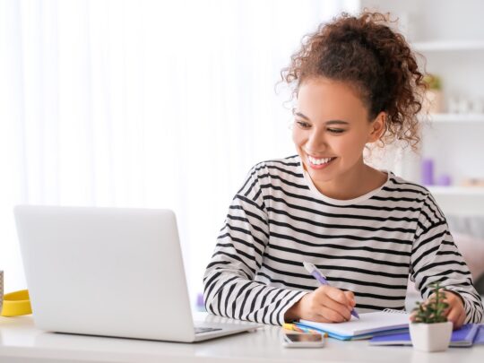 Young woman using laptop for online learning at home